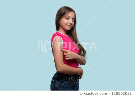 Girl showing arm bandage after vaccination. Girl showing arm bandage after vaccination. 118992081