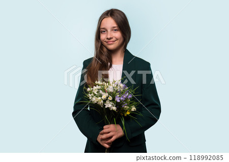 Teen girl holding bouquet of flowers, wearing blazer 118992085