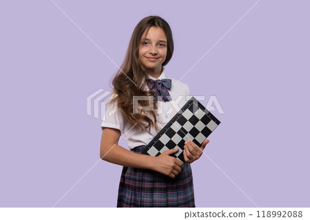 Girl in white shirt and plaid skirt holding checkerboard Girl in white shirt and plaid skirt holding checkerboard 118992088