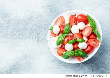 Basil leaves , cherry tomatoes and mozzarella cheese . In bowl food photography Basil leaves , cherry tomatoes and mozzarella cheese . In bowl food photography 118992294