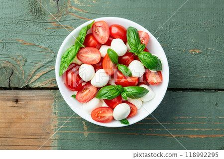 Basil leaves , cherry tomatoes and mozzarella cheese . In bowl food photography 118992295
