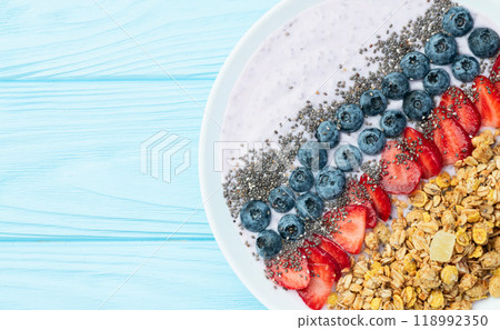 Healthy breakfast . Yogurt with berries ( strawberry , raspberry , blueberry , blackberry ) , granola and chia seeds . Top view 118992350