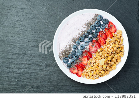 Healthy breakfast . Yogurt with berries ( strawberry , raspberry , blueberry , blackberry ) , granola and chia seeds . Top view 118992351