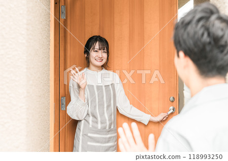 A young Asian woman/wife smilingly seeing off her husband/husband who goes to work in the morning 118993250