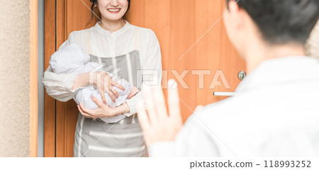 一位年輕的亞洲女性/妻子在早上上班時微笑著送行 一位年輕的亞洲女性/妻子在早上上班時微笑著送行 118993252