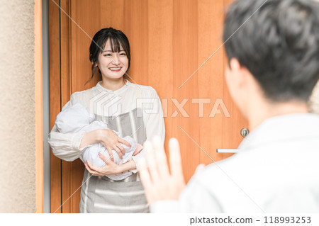 一位年輕的亞洲女性/妻子在早上上班時微笑著送行 一位年輕的亞洲女性/妻子在早上上班時微笑著送行 118993253