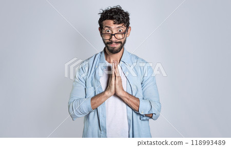 Pleading person asking for a favor, People with a pleading expression asking for a favor. Man putting his hands together asking for a favor 118993489