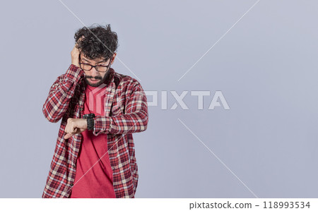 Worried young man looking at the time on the clock, worried man looking at his watch, scared man looking at his watch, isolated 118993534