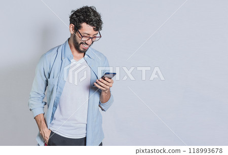 Handsome man smiling and using mobile phone isolated, People smiling and looking at ad on cell phone. Person in glasses smiling using smartphone on isolated background Handsome man smiling and using mobile phone isolated, People smiling and looking at ad on cell phone. Person in glasses smiling using smartphone on isolated background 118993678