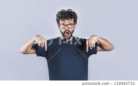 Amazed man pointing down isolated, Shocked person pointing down with fingers isolated, Amazed young man pointing down 118993710