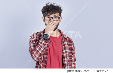 Person holding his nose looking at camera, people holding his nose with unpleasant smell expression, young man with bad smell expression holding his nose Person holding his nose looking at camera, people holding his nose with unpleasant smell expression, young man with bad smell expression holding his nose 118993732