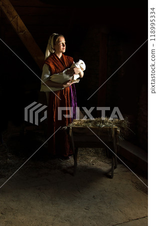 Mary in the stable near the manger with the baby Mary in the stable near the manger with the baby 118995334