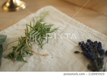 Fresh spring of rosemary and lavender on linseed tablecloth. Wooden table. Work with herbs 118995920