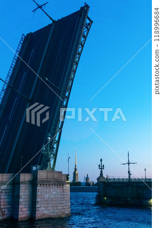 raised Liteyny Bridge in St. Petersburg on a white night, the Peter and Paul Cathedral is visible in the background raised Liteyny Bridge in St. Petersburg on a white night, the Peter and Paul Cathedral is visible in the background 118996684