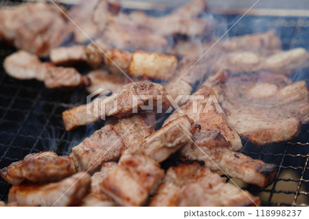 Close-up of pork belly being grilled on a charcoal grill. 118998237