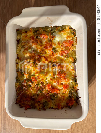 Close-up delicious homemade baked pasta casserole with melted cheese and vegetables. Italian cuisine food for a hearty meal 118998644