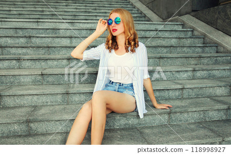 Beautiful young woman model sitting on the stairs on city street 118998927