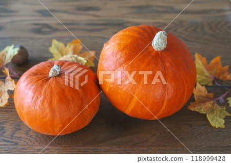Orange pumpkins with autumn leaves on a wooden table. Halloween, Thanksgiving day holiday decor 118999428