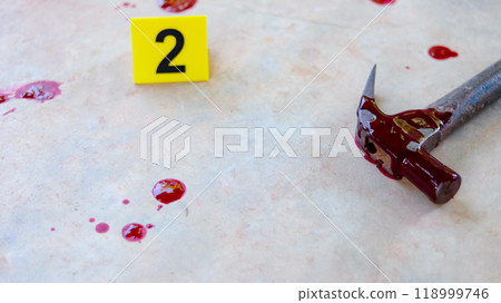 A bloodstained steel hammer lying on a concrete floor, with a blurred yellow marker number 2 and scattered blood drops, symbolizing a violent crime scene under investigation. A bloodstained steel hammer lying on a concrete floor, with a blurred yellow marker number 2 and scattered blood drops, symbolizing a violent crime scene under investigation. 118999746