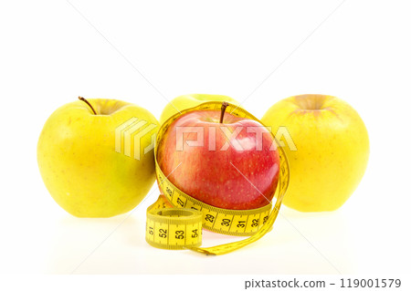 Apples of red and yellow colors wrapped with measuring tape Apples of red and yellow colors wrapped with measuring tape 119001579