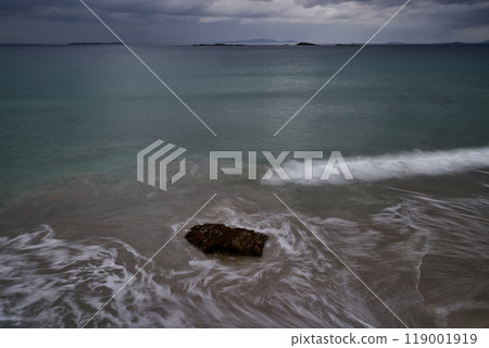 long exposure beach waves around rock cloudy day long exposure beach waves around rock cloudy day 119001919