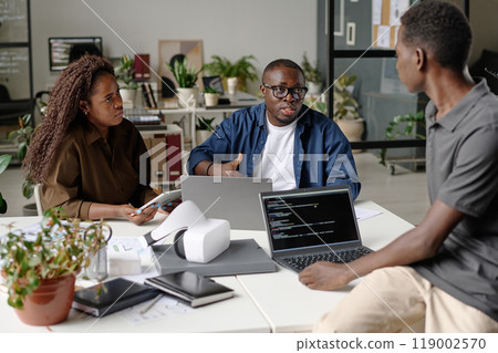 Young and talented IT team of famous company discussing new product in modern office 119002570