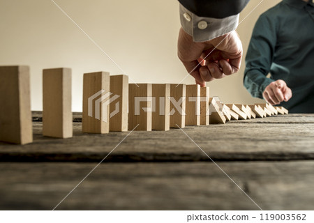 Businessman stopping the domino effect 119003562