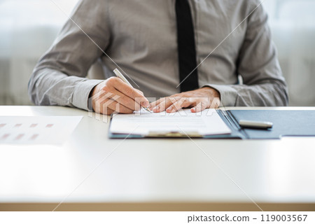 Businessman or lawyer signing a document 119003567