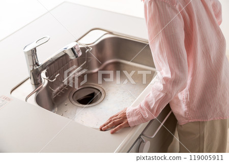 一位老年婦女正在檢查出租公寓的廚房 119005911