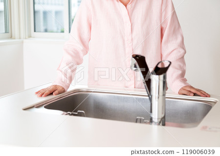 一位老年婦女正在檢查出租公寓的廚房 一位老年婦女正在檢查出租公寓的廚房 119006039