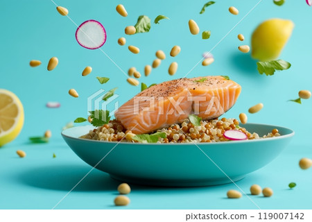 A chunk of fresh salmon floating alongside radish, lemon, and pine nuts with a turquoise backdrop 119007142