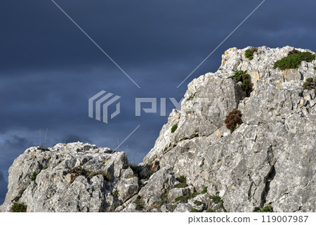 Close-up of rugged rock formation under dramatic cloudy sky Close-up of rugged rock formation under dramatic cloudy sky 119007987