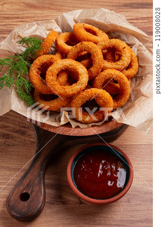 Deep fried onion rings, appetizer, with tomato sauce, on a wooden table, no people, favorite dish, 119008028