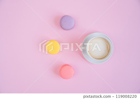 Tasty sweet macarons and cup of fragrant coffee. French macaroons on pink background. Tasty sweet macarons and cup of fragrant coffee. French macaroons on pink background. 119008220