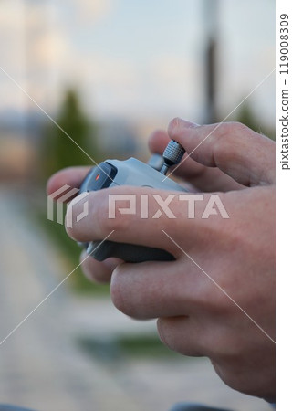 Male hands hold drone control panel. Management by quadcopter flight Male hands hold drone control panel. Management by quadcopter flight 119008309