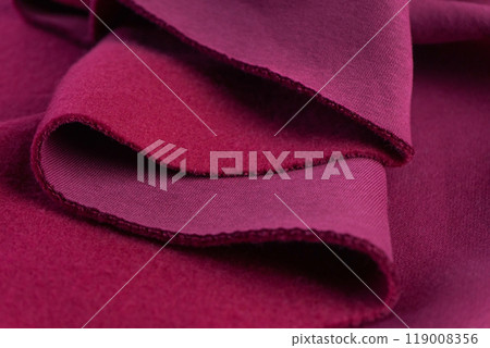 layers of French terry pink amaranth textile. A piece of fabric lies in beautiful waves. 119008356