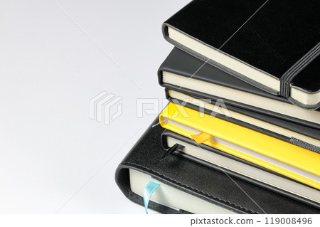 Close up Piles of luxury Leather Agenda Diary Notebook, or appointment book with bookmark stripe isolated on white background. Stationery item. 119008496