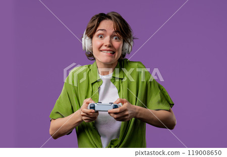 Young pretty gamer woman playing online video game on console with joystick 119008650