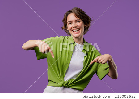 Charming woman pointing down advertising area.Violet background. Click subscribe 119008652