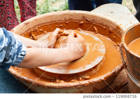 Pottery training. Rotating a clay pot on a machine. Hands knead clay. Making a clay pot. 119008716