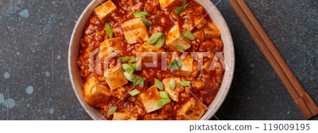 Mapo tofu garnished with green onions in bowl top view, traditional Chinese dish 119009195