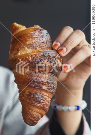 woman hand pick fresh baked croissant  119009396