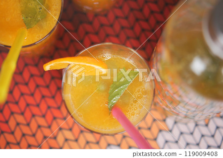 A Refreshing Orange Mint Beverage served with Colorful Straws for charm and appeal 119009408
