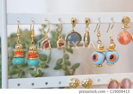 An Exquisite Collection of Beautifully Colorful Earrings Tastefully Displayed on a Stand 119009415