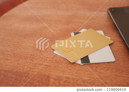 A collection of Credit Cards elegantly displayed on a Wooden Table along with a Laptop A collection of Credit Cards elegantly displayed on a Wooden Table along with a Laptop 119009419