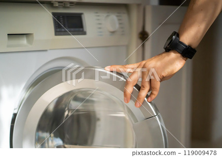 Man is using the modern washing mashine. Man is using the modern washing mashine. 119009478