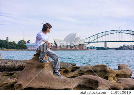 A Japanese man relaxing in front of the Sydney Opera House A Japanese man relaxing in front of the Sydney Opera House 119010919