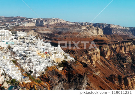Top view of the white houses on the mountainside with churches and domes in Thira, Santorini island. 119011221