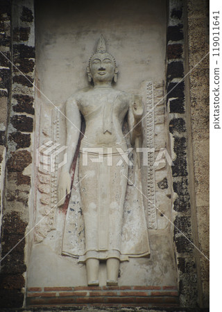 Outdoor Ancient standing stucco Buddha at Main Pagoda ( Prang ) in Wat Ratchaburana ruins is considered a very important temple is Unesco World Heritage Site in Ayutthaya Historical Park in Thailand. 119011641