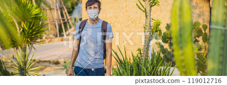 BANNER, LONG FORMAT beautiful stylish young man in desert among the cacti, wearing a medical mask during COVID-19 coronavirus, traveling in Africa on safari, exploring nature, sunny summer, traveler BANNER, LONG FORMAT beautiful stylish young man in desert among the cacti, wearing a medical mask during COVID-19 coronavirus, traveling in Africa on safari, exploring nature, sunny summer, traveler 119012716